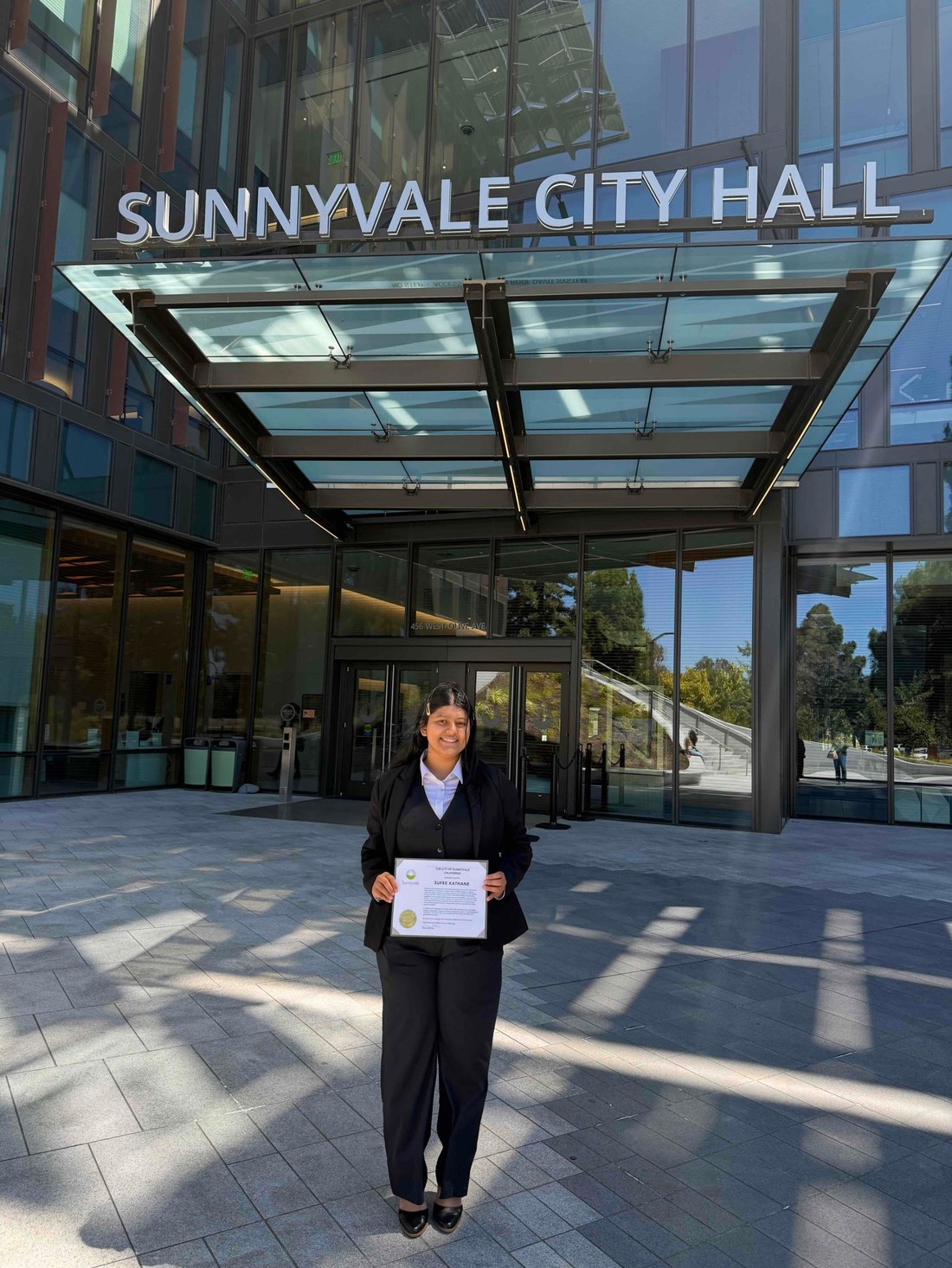 Sufee Kathane at Sunnyvale City Hall holding a certificate of recognition